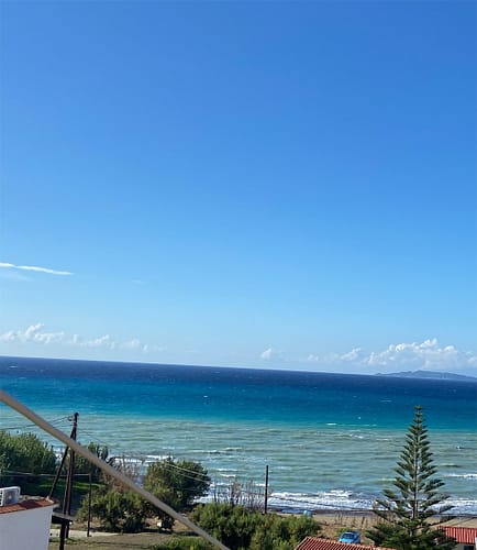 Strahlend blauer Himmel und azurblaues, welliges Meer